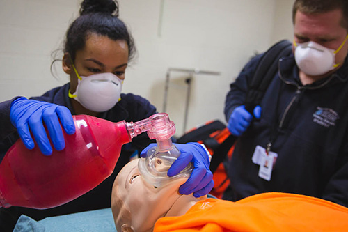 EMT students work to revive a patient simulator