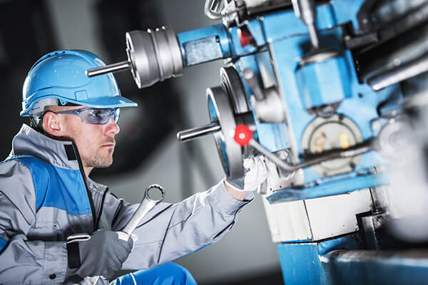 A maintenance mechanic works on industrial machinery