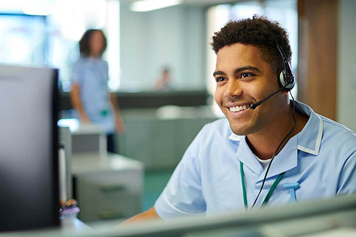 A health professional works at a computer