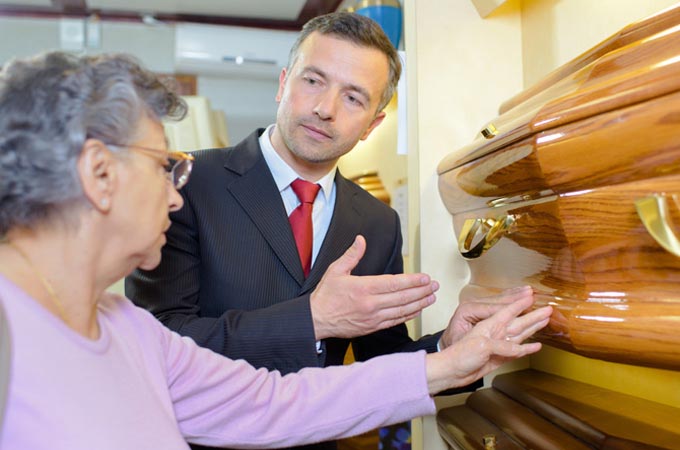 funeral services director shows coffin to client