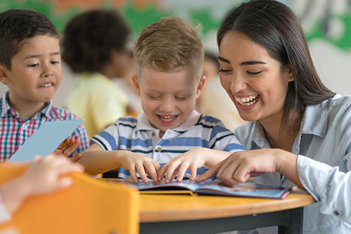 A teacher works on reading with to students