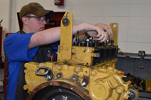 A student works on a diesel engine in the Transportation center