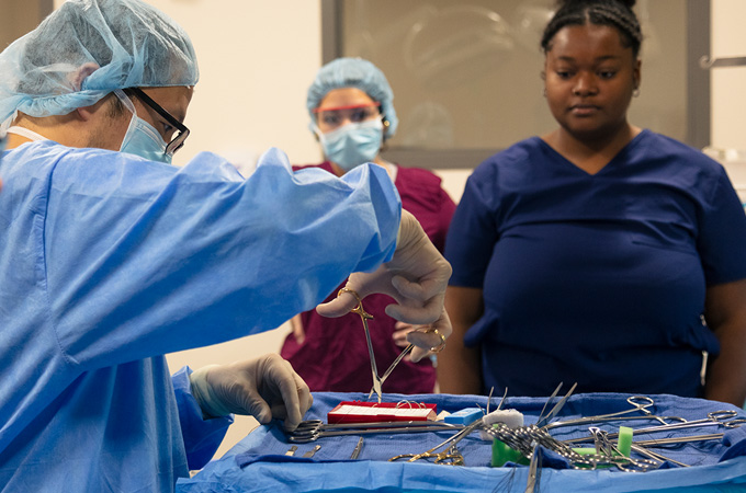 A person in scrubs preps tools for surgery