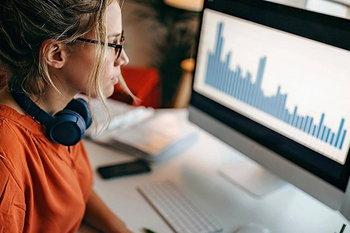 A woman works on a bar chart on her PC