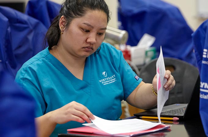 A medical assistant looks through a patient's chart