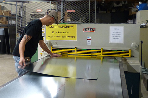 A technician loads sheet metal into a machine