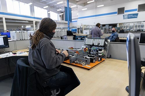 Student in a mask works on automation