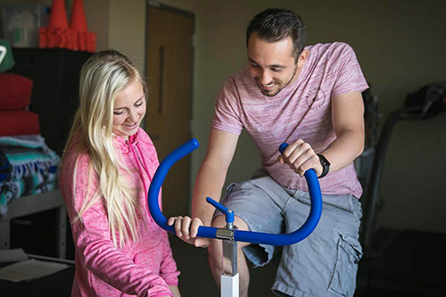 A wellness student advises a patient on exercise methods