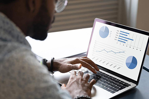 A man works on data visualizations on his laptop