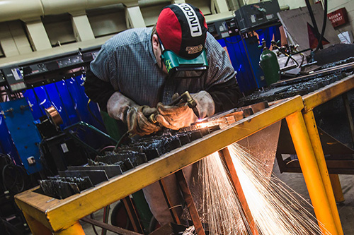 A student welds in the welding lab