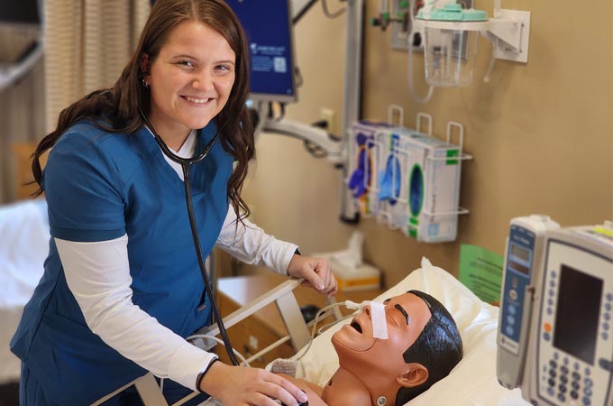 Student in scrubs assesses a patient