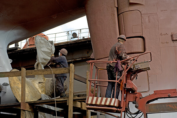 Two welders work on a ship