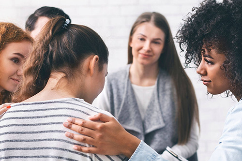 A group meets for therapy with a counselor