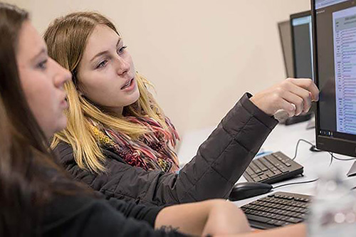 Two students work at a computer