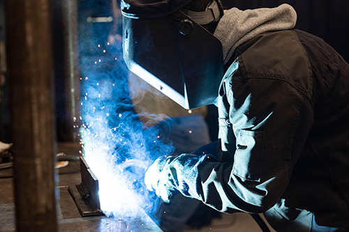 A student welding in protective gear