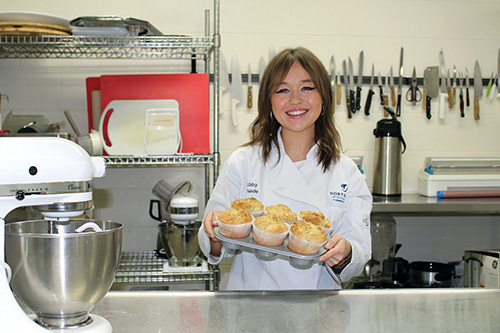 A student holds up pastries made in the culinary lab