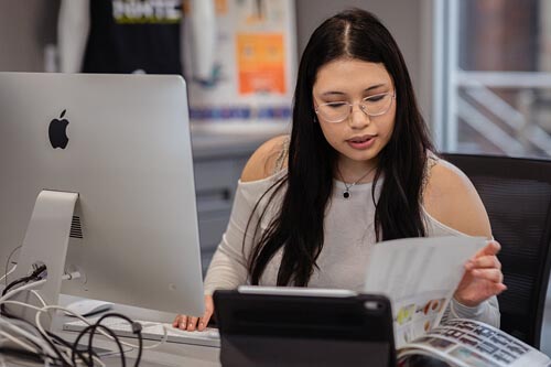 Student reviews designs on paper and computer