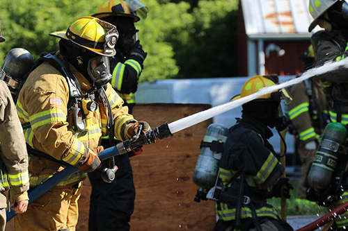 A firefighter sprays water at the scene of a fire