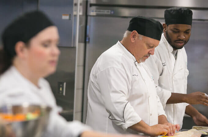 Students create a dish in the culinary lab