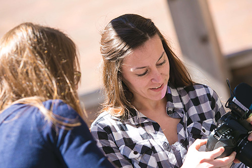 Two students review photos taken on a digital camera