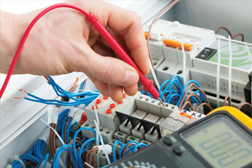 closeup of a person working on electrical components with a tool