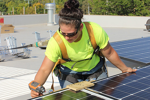 A female worker adjusts solar panels