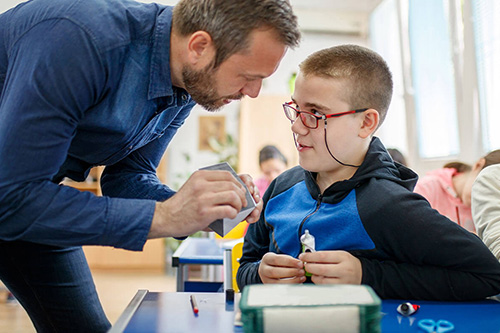 A teacher works one on one with a special needs student