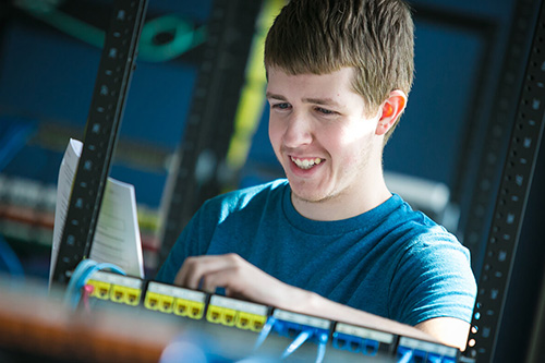 A student works on a server in a rack