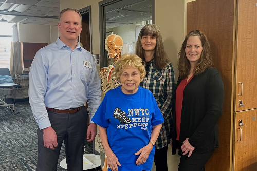 Jacque Steeno poses in a "Keep Stepping" t-shirt with NWTC staff members and instructors
