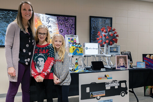 Kristin Helms with her family in front of a final project. 