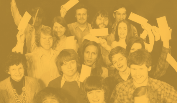 Students in the 1970s hold their scholarship checks.