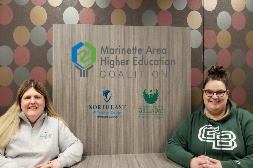 Kelly Thompson and Katie Mulzer with the Marinette Higher Education Coalition logo.