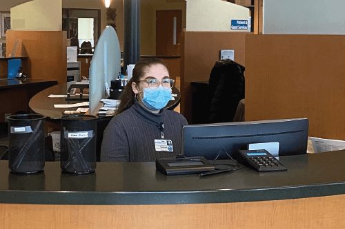 NWTC alumna Natalia Ayala sits at a welcome desk