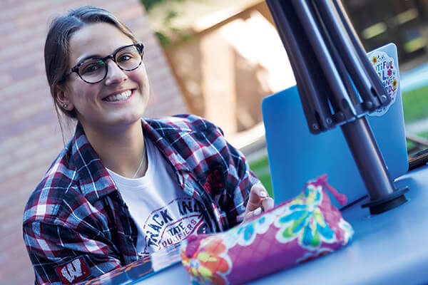 NWTC student enjoying summer weather on the Green Bay campus patio. 