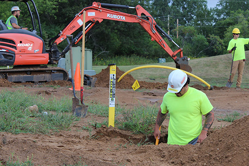 Workers dig a trench for gas line installation