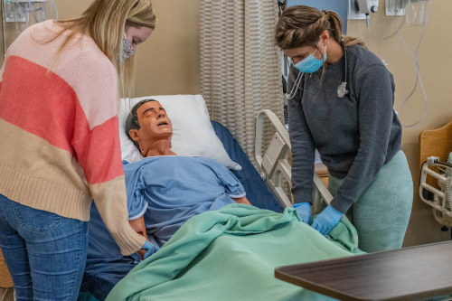 Two female Nursing students work on a patient simulator