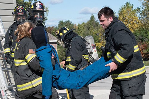 Public Safety Students rescue a patient simulator from a burning building