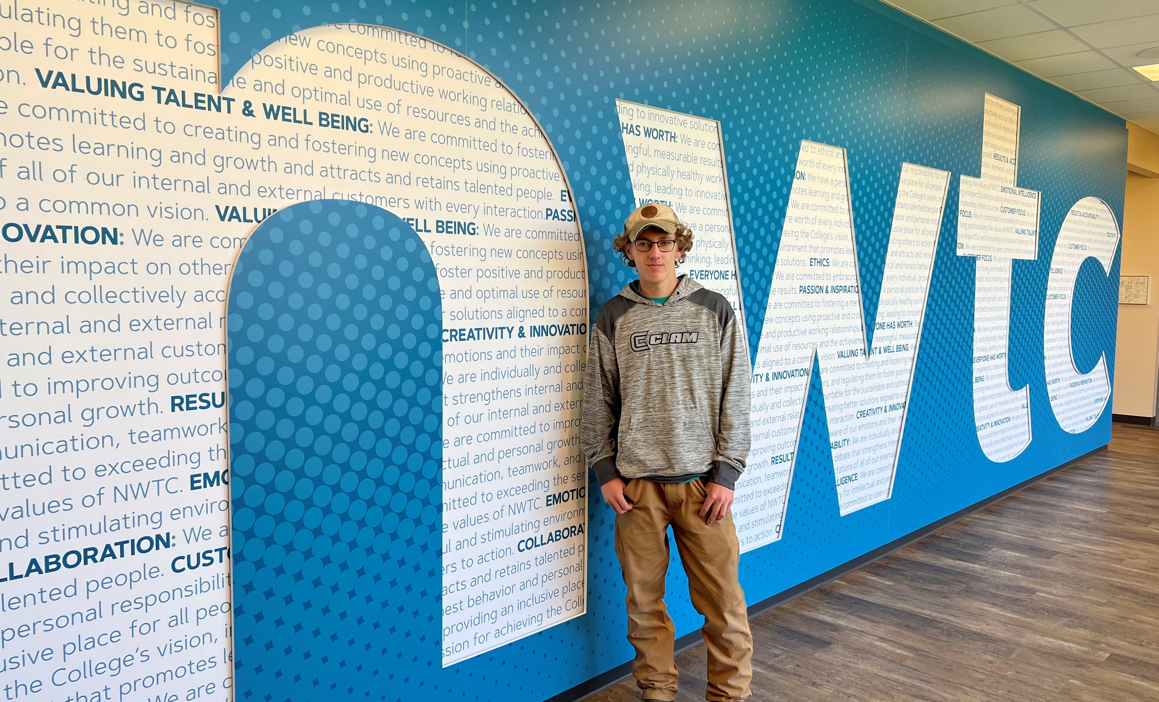 Peyton Betts poses for a picture in front of NWTC sign
