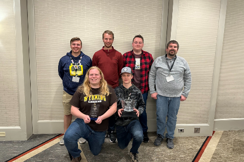 Civil Engineering students Deegan Kossman, Matheu Pietro, Seth Sanders, Dalton Carrick, and Ethan Karls pose with instructor Mark Kamin and 1st place trophy