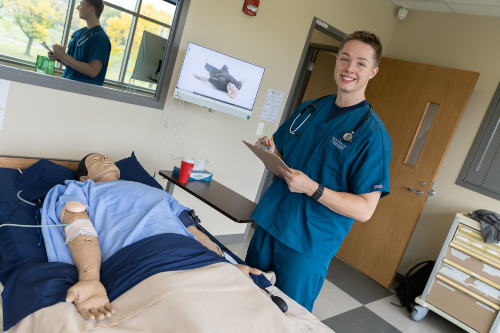 Austin Beth practices nursing skills on a manikin