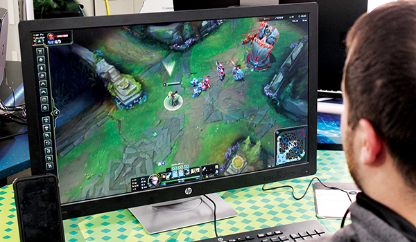 Male student playing computer game on the computer in eSports Zone.