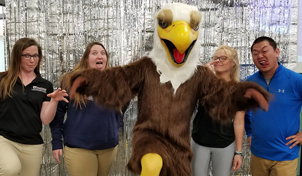 Admissions staff pose with the NWTC Eagle