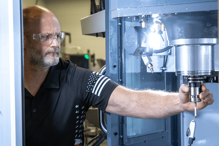 Student wearing safety glasses adjusts machine