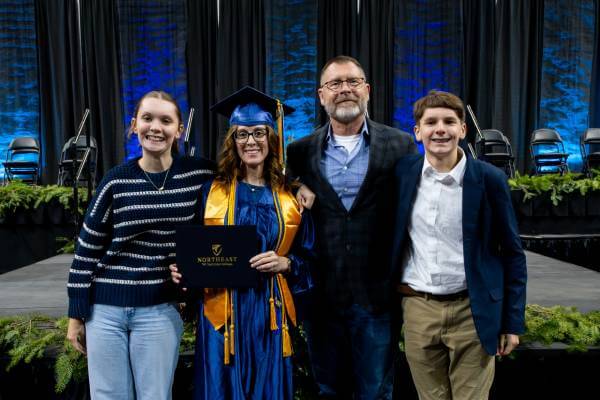 Rachel McIntosh and her family standing, facing camera, during Dec. 17, 2025, commencement ceremony