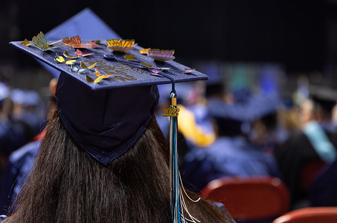 A student with a decorated mortarboard at graduation