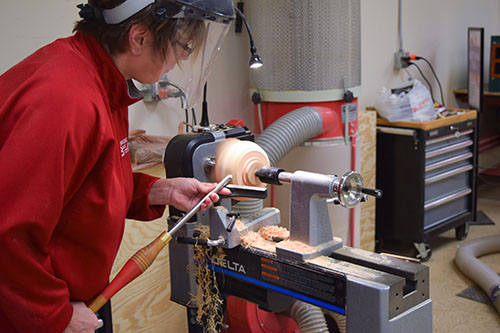 Woman at woodturning lathe