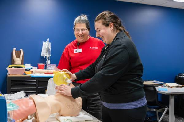 Diana Lawler smiles, working with her daughter, Brooke, in class