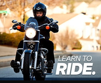 Man riding motorcycle with learn to ride text.