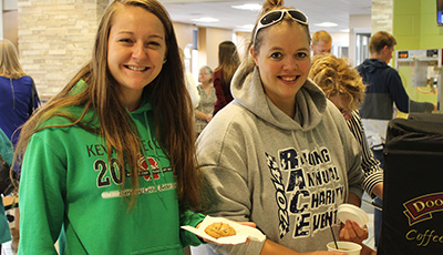 Students smile while eating in the commons