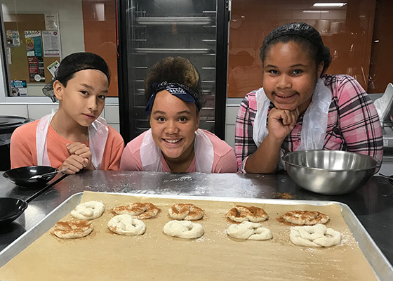 Middle school students make treats in the culinary lab during a campus tour